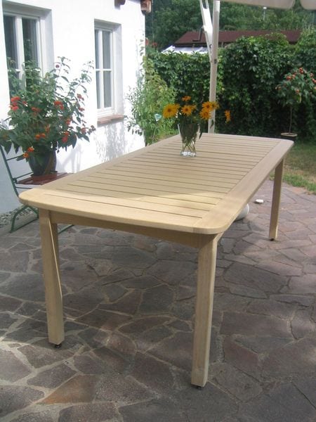 Langer Gartentisch aus Massivholz auf einer Terrasse