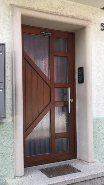 Dunkle Haustür aus Holz im Eingang eines Altbaus