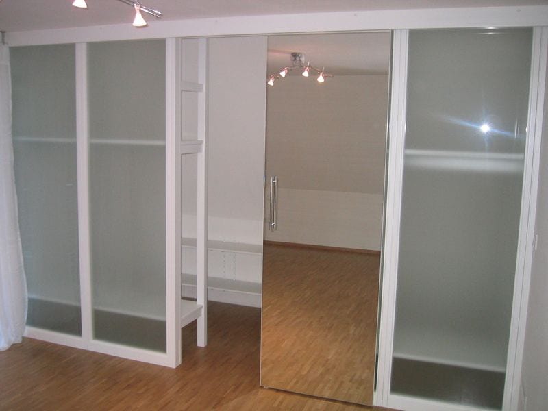 Raumteiler mit großen Glas-Schiebetüren in einem hellen Wohnraum