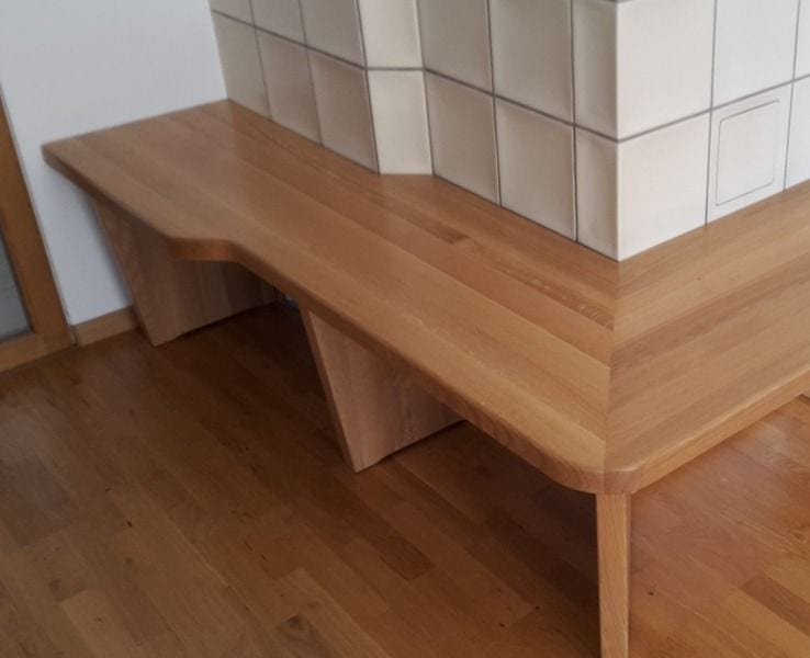 Sitzbank aus Massivholz, passgenau an einen Kachelofen gebaut