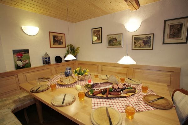 Gedeckter Tisch mit umlaufender Eckbank aus Holz in einer Stube