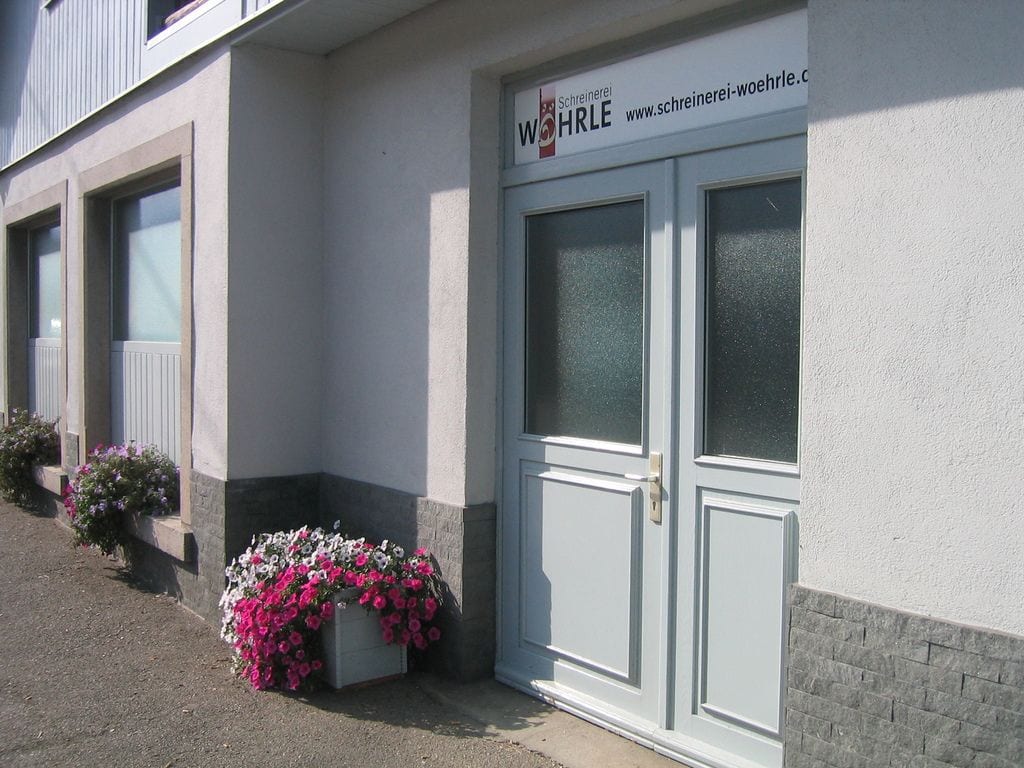 Eingang der Schreinerei Wöhrle auf dem Steingrün in Gutach mit Firmenschild und Blumenkästen